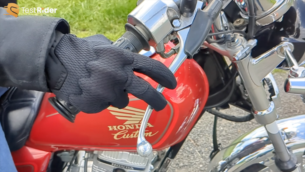 Présentation sur une poignée de moto des protections de phalanges des racer roca 3 f