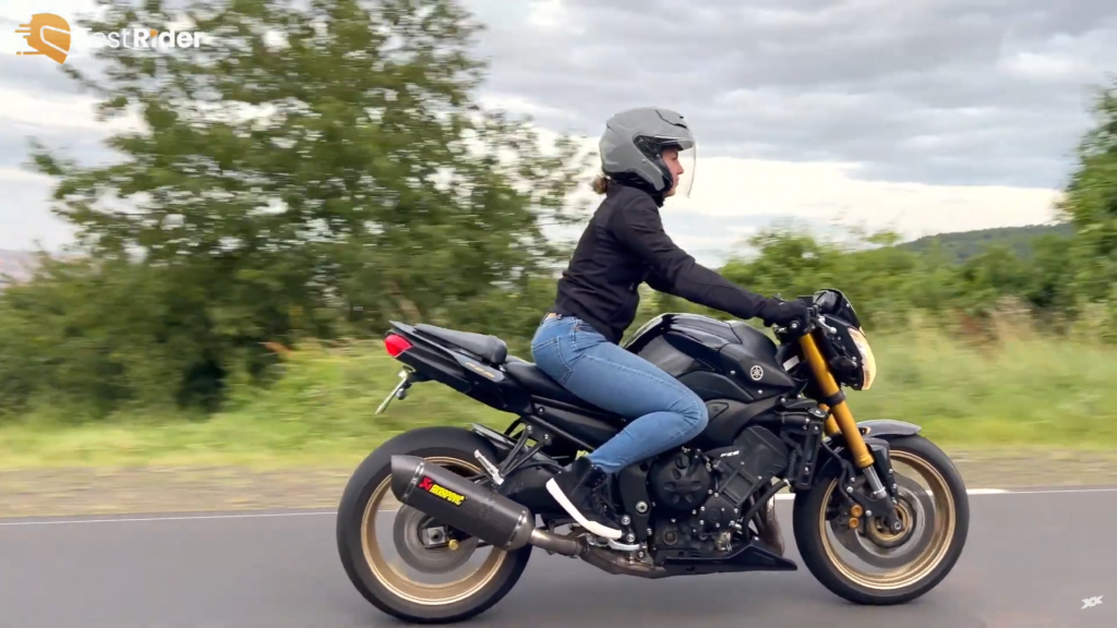 Axelle porte le casque sur la route et on la voit passer à côté